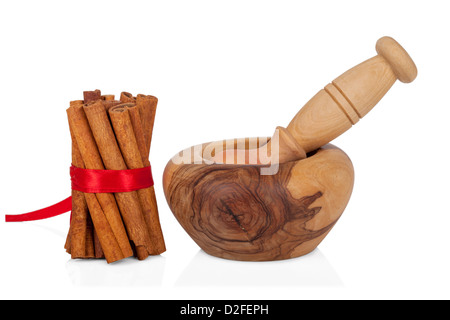 Cannelle avec mortier et pilon isolé sur fond blanc Banque D'Images