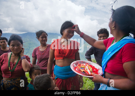 Sanamaya Chepang est de donner aux personnes Tika collecte locale, une tradition hindoue signifiant bonne chance et de la santé. Banque D'Images