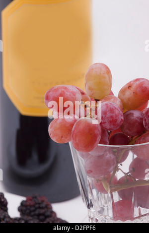 Bouteille de vin rouge et le verre rempli de raisins Banque D'Images