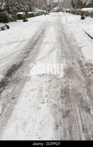 Route traîtresse surface recouverte de neige gelée glace mouillée avec marques de dérapage et les traces de pneus sur un jour de collecte refuge Banque D'Images