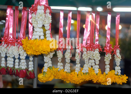 La guirlande de fleurs utilisées comme offrandes et bénédictions pour la vente sur un stand de rue à Bangkok, Thaïlande Banque D'Images