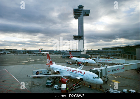 Virgin America deux Airbus A320 avions à se tenir en face de la tour de contrôle à l'aéroport John F. Kennedy, JFK, New York, USA au crépuscule comme ils sont chargés pour leur prochain vol. Banque D'Images