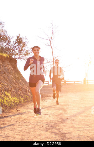 Un coureur masculin et une femme profitent d'une course de trail au coucher du soleil à Griffith Park, Los Angeles, Californie Banque D'Images