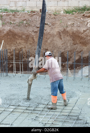 Builder avec des travailleurs de tube monté sur camion pompe à béton de ciment coulée en renfort de coffrage Banque D'Images