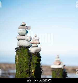 Des piles de pierres au-dessus d'un épi en bois sur la plage de Porlock Weir, Somerset, England, United Kingdom Banque D'Images