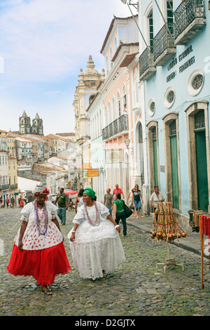 Baianas marchant le long d'une rue pavée du centre historique de Salvador de Bahia, Brésil Banque D'Images