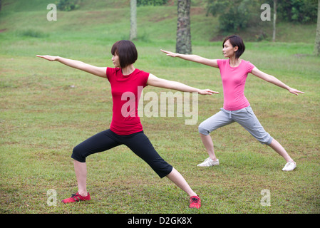 Les amis de fille , plein air de guerrier yoga pose Banque D'Images
