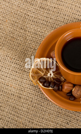 Photo de gros plan de coupe fraîchement préparé avec de la cannelle, de l'espresso italien café les haricots, les noix et citron sur limogeage Banque D'Images