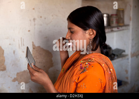 L'Inde, l'Uttar Pradesh, Agra adolescente se brosser les dents avec des preuves claires de piqûres de moustiques sur le visage Banque D'Images
