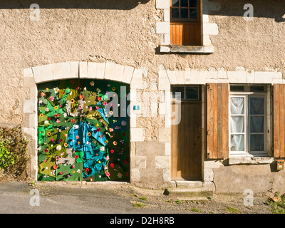 Décoration de porte de garage avec des vêtements et des fleurs en plastique - France. Banque D'Images