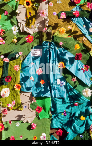 Décoration de porte de garage avec des vêtements et des fleurs en plastique - France. Banque D'Images