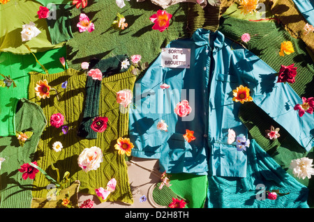 Décoration de porte de garage avec des vêtements et des fleurs en plastique - France. Banque D'Images