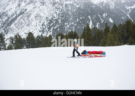 Ski alpin de sauvetage dans les Pyrénées d'Andorre. Un skieur blessé retourne au centre médical par une patrouille de neige médic attaché dans un traîneau. Banque D'Images