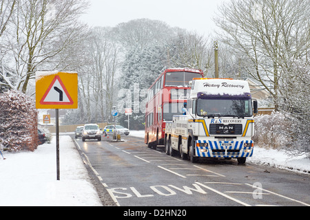 Un bus est remorqué après avoir été frappé par une voiture dans la neige Banque D'Images