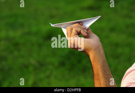 La tenue d'un avion en papier dans la main Banque D'Images