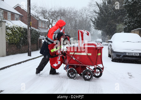 Facteur distribue le courrier dans une chute de neige. Banque D'Images