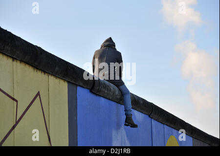 Ein Mann sitzt am 25.01.2013 dans Mauerteil auf einem der Berlin East Side Gallery. Foto : Paul Zinken/dpa un homme est assis sur une partie de l'ancien mur Berlion à la East Side Gallery à Berlin, Allemagne, 25 janvier 2013. Photo : Paul Zinken Banque D'Images