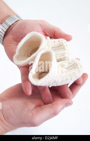 Les parents holding self-made bottes enfant dans leurs mains. Banque D'Images