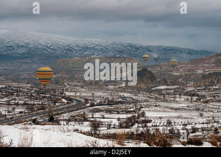 Montgolfières décoller tôt le matin plus de lumière de la ville de Göreme en Cappadoce à l'hiver, l'Anatolie centrale de la Turquie. Banque D'Images