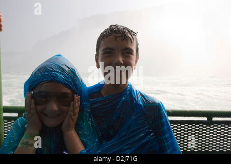 Les enfants dans des imperméables à bord du Maid of the Mist excursion en bateau dans la région de Niagara Falls, Canada Banque D'Images