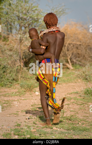 Hamar woman holding her baby- de l'arrière Banque D'Images