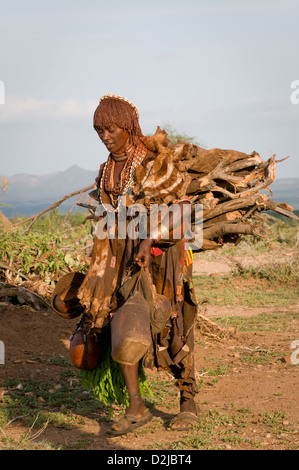 Hamar woman walking, transportant du bois et les gourdes Banque D'Images