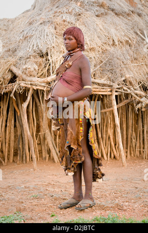 Hamar pregnant woman standing in front of hut Banque D'Images