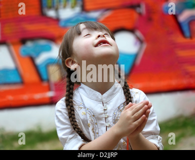 Portrait de belle jeune fille priant sur l'aire de jeux Banque D'Images