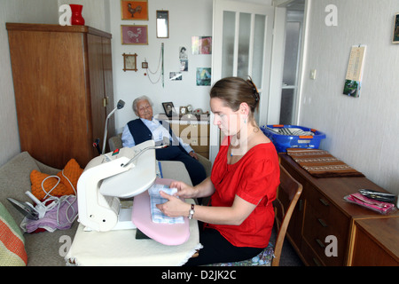 Berlin, Allemagne, une jeune femme d'aider une femme âgée pendant le repassage Banque D'Images
