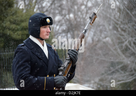 Un soldat prend part à la cérémonie de relève de la garde devant la tombe de l'inconnu au cimetière national d'Arlington dans la neige. Banque D'Images