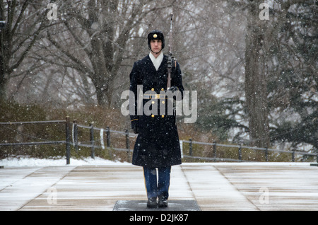 Un soldat monte la garde dans la neige qui tombe sur le tombeau de l'inconnu au cimetière national d'Arlington dans la neige. Le garde s'engage dans un jeu de routine dans laquelle il marches 21 marches à descendre le mat noir derrière le tombeau, tourne, fait face à l'est pour 21 secondes, se retourne et fait face au nord pendant 21 secondes, puis prend 21 pas en bas de la mat et répète le processus. Banque D'Images