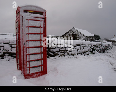 Boîte téléphonique rouge traditionnelle recouverte de neige, Dartmoor, Devon, Royaume-Uni, janvier Banque D'Images