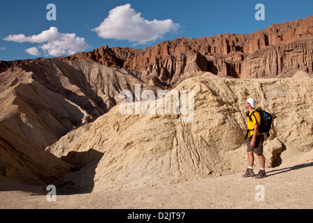 Un randonneur donne sur les Montagnes Noires lors d'une soirée randonnée pédestre de Golden Canyon dans Death Valley National Park, en Californie. Banque D'Images