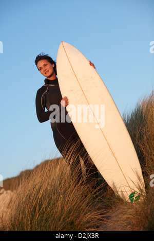 Jeune femme debout sur surfeur surf holding sand dune Banque D'Images