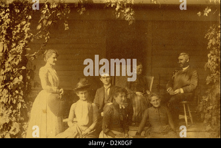 Vers 1890, photographie de la carte du cabinet famille Victorienne sur le porche de la maison avec vignes. Banque D'Images