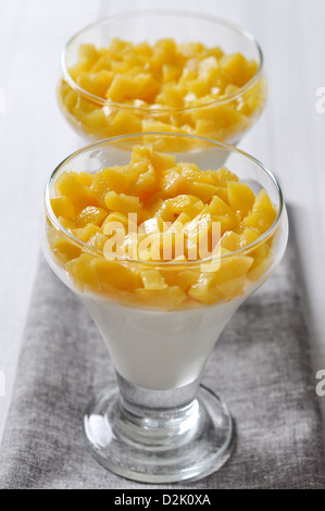 Panna cotta dessert italien avec peach dans les verres Banque D'Images