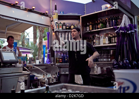 Carnaval Cour Bar & Grill, un barman tourne lors de bouteilles de boissons pour les clients Banque D'Images