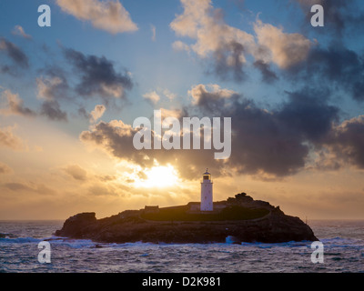 Soleil derrière le phare de Godrevy Island au large de la côte de Cornwall England UK Banque D'Images
