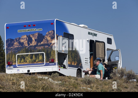Décoré Cruise America loué motorhome avec les rv'ers se détendant à côté Véhicule à Yellowstone Wyoming, États-Unis Banque D'Images