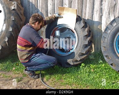 Homme de plein air tracteur coloriage adultes avec pulvérisateur air couleur Banque D'Images