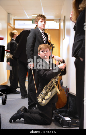 Un garçon avec son saxophone avant un concert à Pates Grammar School à Cheltenham, Gloucestershire UK Banque D'Images