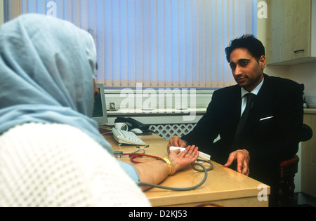 GP Sikh avec femelle Asian patient en salle de consultation, Southall, Middlesex, Royaume-Uni. Banque D'Images