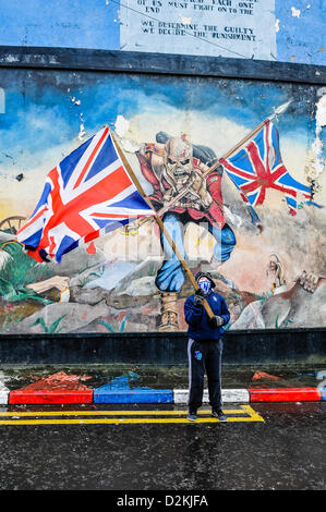 27 janvier 2013, à Londonderry, en Irlande du Nord. Un jeune garçon protestant détient un drapeau de l'Union devant un mur murale, copié à partir de l'Iron Maiden album 'The Trooper'. Banque D'Images