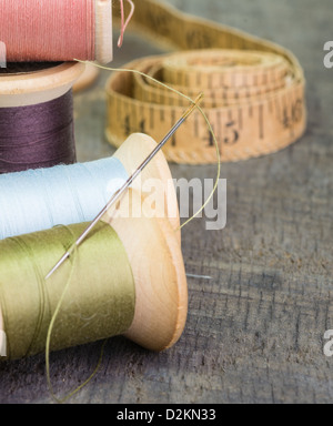 Couture d'un ruban de mesure avec des bobines de fil et une aiguille Banque D'Images