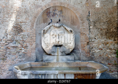 Aventino. Rome. Vue sur le mur extérieur de la Santa Sabina mascherone (masque) utilisés dans la fontaine du 16ème siècle Banque D'Images