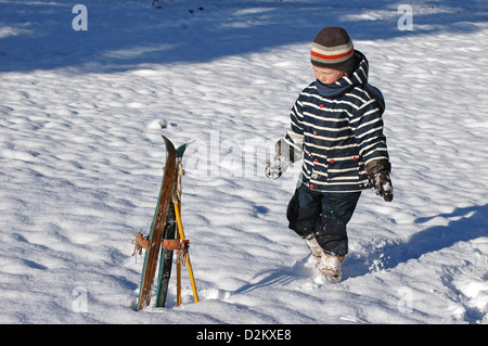 Paire de skis enfant ancienne en bois avec quatre ans garçon Banque D'Images