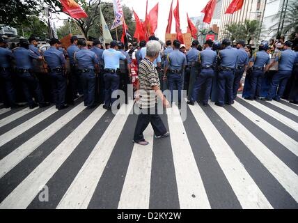 Manille, Philippines. 28 janvier 2013. Une personne traverse la route comme : une manifestation devant l'ambassade américaine à Manille, Philippines, le lundi 28 janvier, 2013. Des manifestants sont à demander l'abrogation de l'US-Philippines Visiting Forces Agreement au milieu d'opérations en cours pour supprimer un démineur de la marine américaine qui s'est échoué sur le récif de Tubbataha, un site du patrimoine mondial. Ezra Acayan / Alamy Live News Banque D'Images