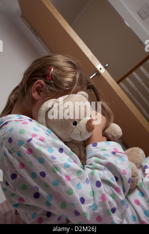 Jeune femme portant un pyjama serrant son ours en peluche. Banque D'Images