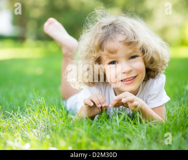 Heureux enfant jouant sur l'herbe verte dans la région de Spring Park Banque D'Images