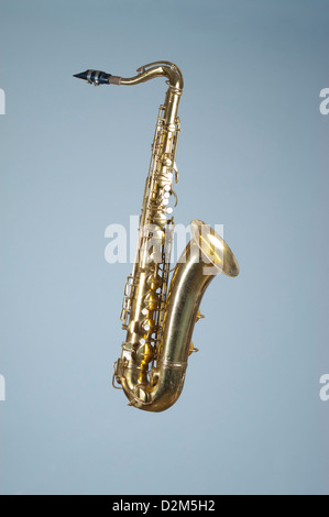 Un saxophone ténor, touches avec pearl inlay, tourné sur fond bleu offre beaucoup d'espace pour copier votre propre message. Banque D'Images